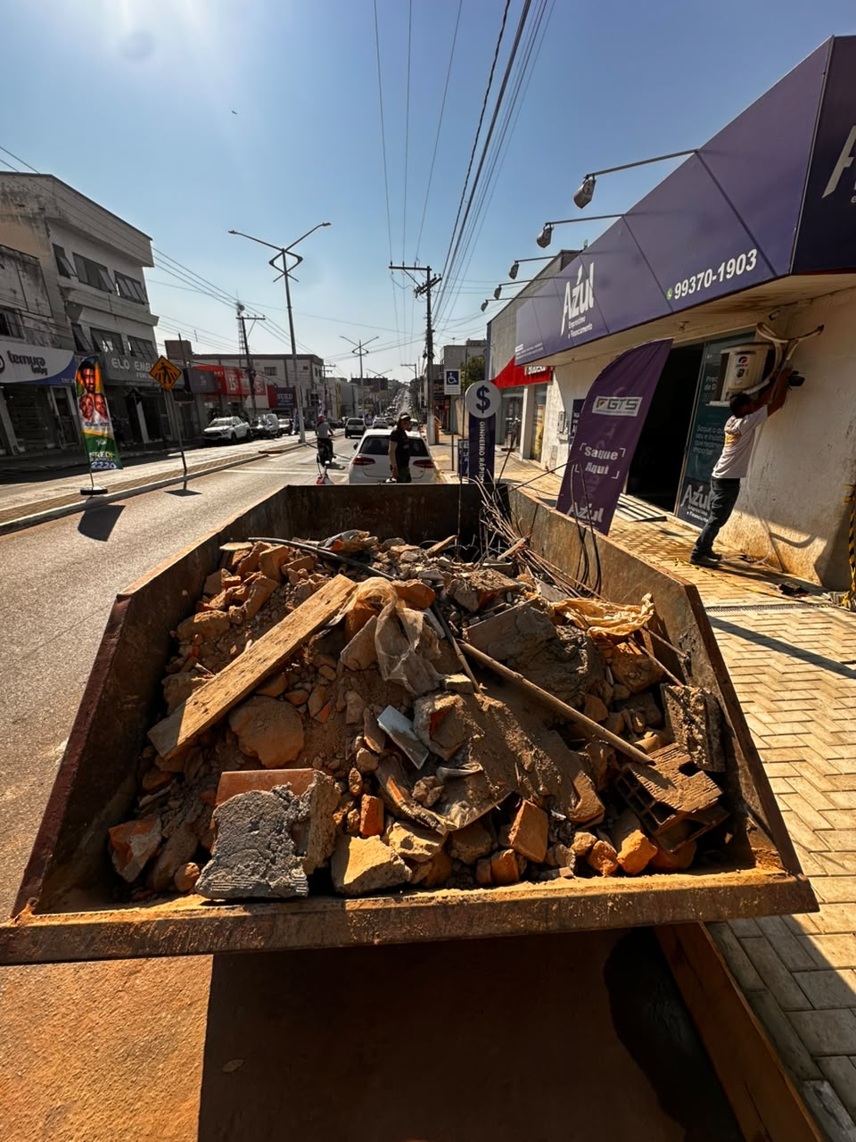 Caçamba cheia com materiais de construção em uma rua de Uruaçu